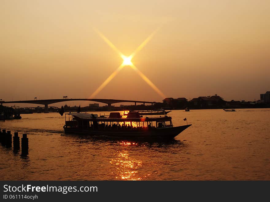 Shuttle boat crossing a river in Bangkok at sunset. Shuttle boat crossing a river in Bangkok at sunset