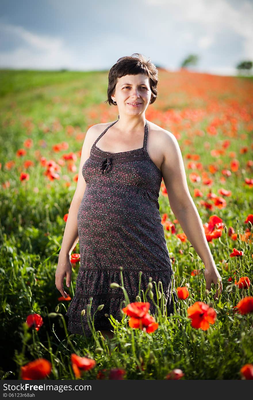 Pregnant Happy Woman In A Flowering Poppy Field