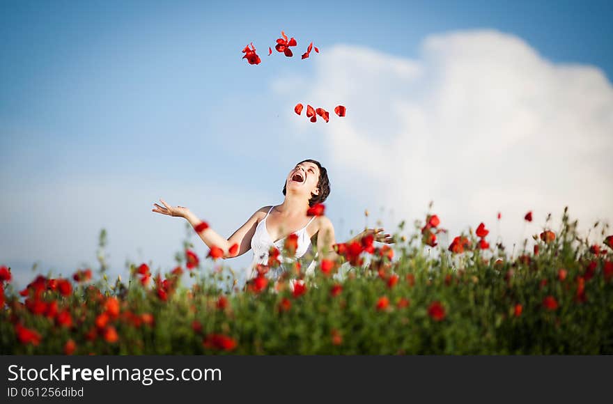 Pregnant happy woman in a flowering poppy field