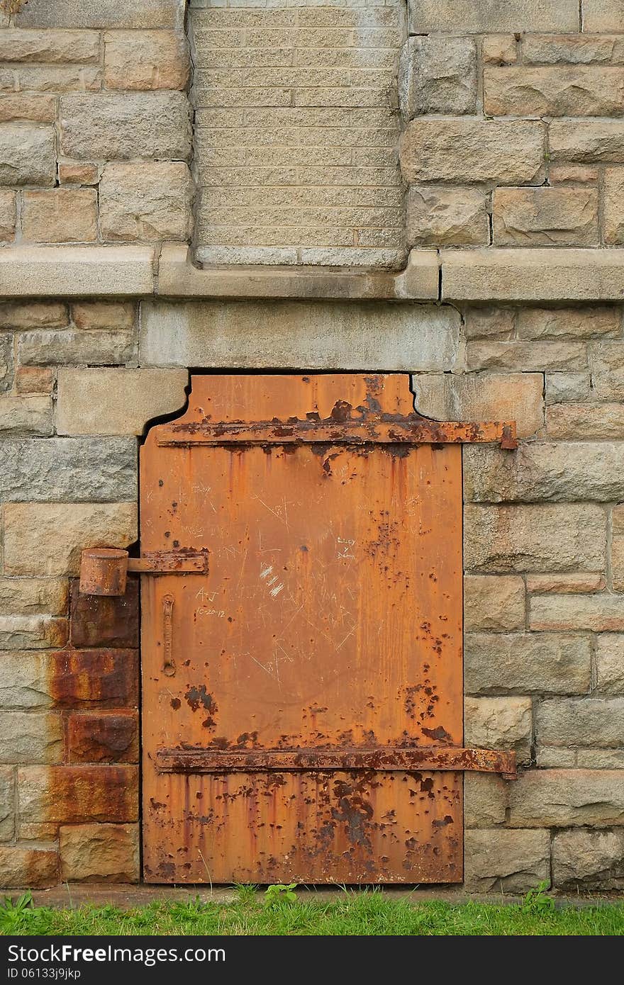 A rustic, weathered steel door is shown in stone door. A rustic, weathered steel door is shown in stone door.