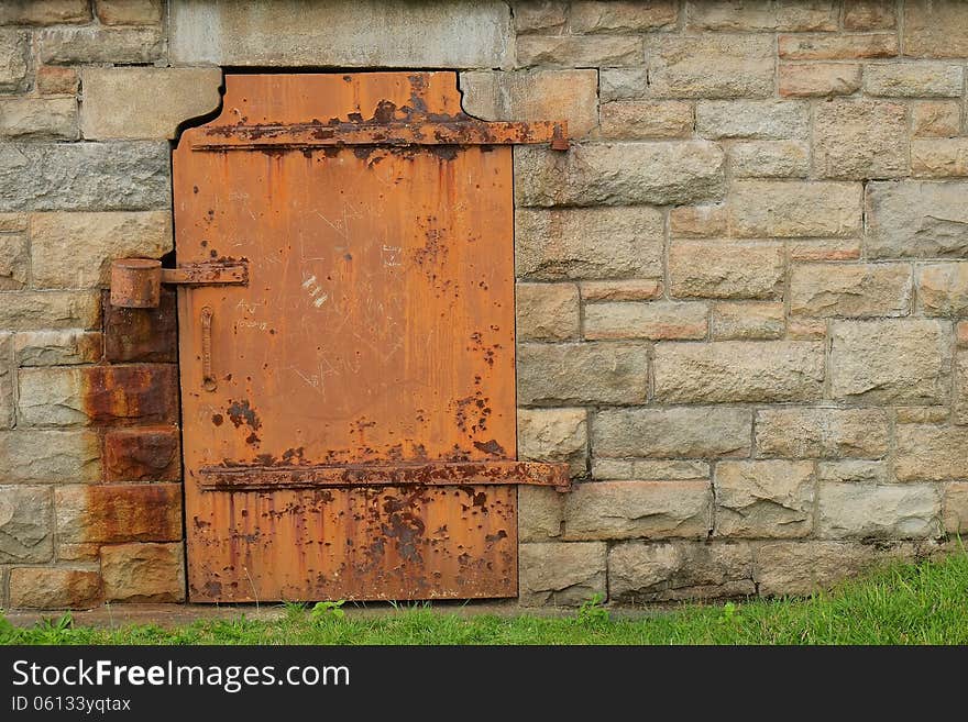 A rustic, weathered steel door is shown in stone door. A rustic, weathered steel door is shown in stone door.