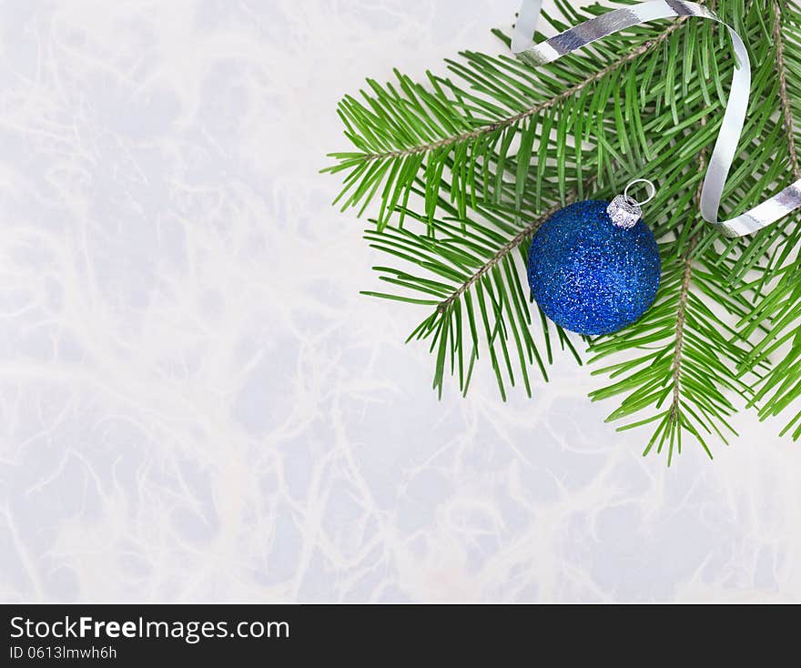 Christmas ball with fir-tree twigs on abstract background