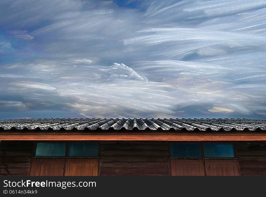 The Moving of Freezing Cloud in Blue Sky Over Roof of Wooden House.