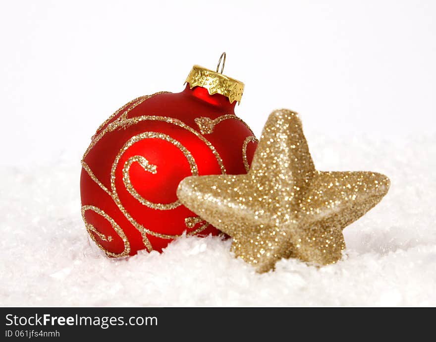 Red-golden baubles and golden star on the snow. Red-golden baubles and golden star on the snow