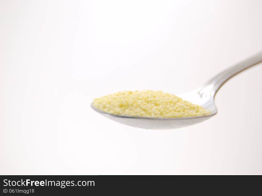 Millet in a spoon on white background.