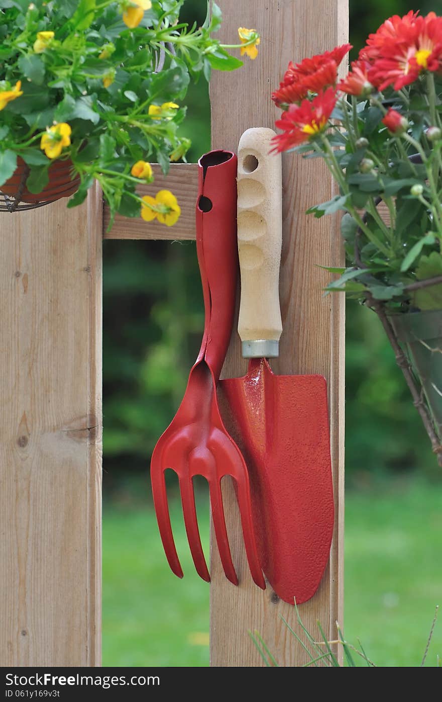 Gardening tools and flower pot hanging on a fence. Gardening tools and flower pot hanging on a fence