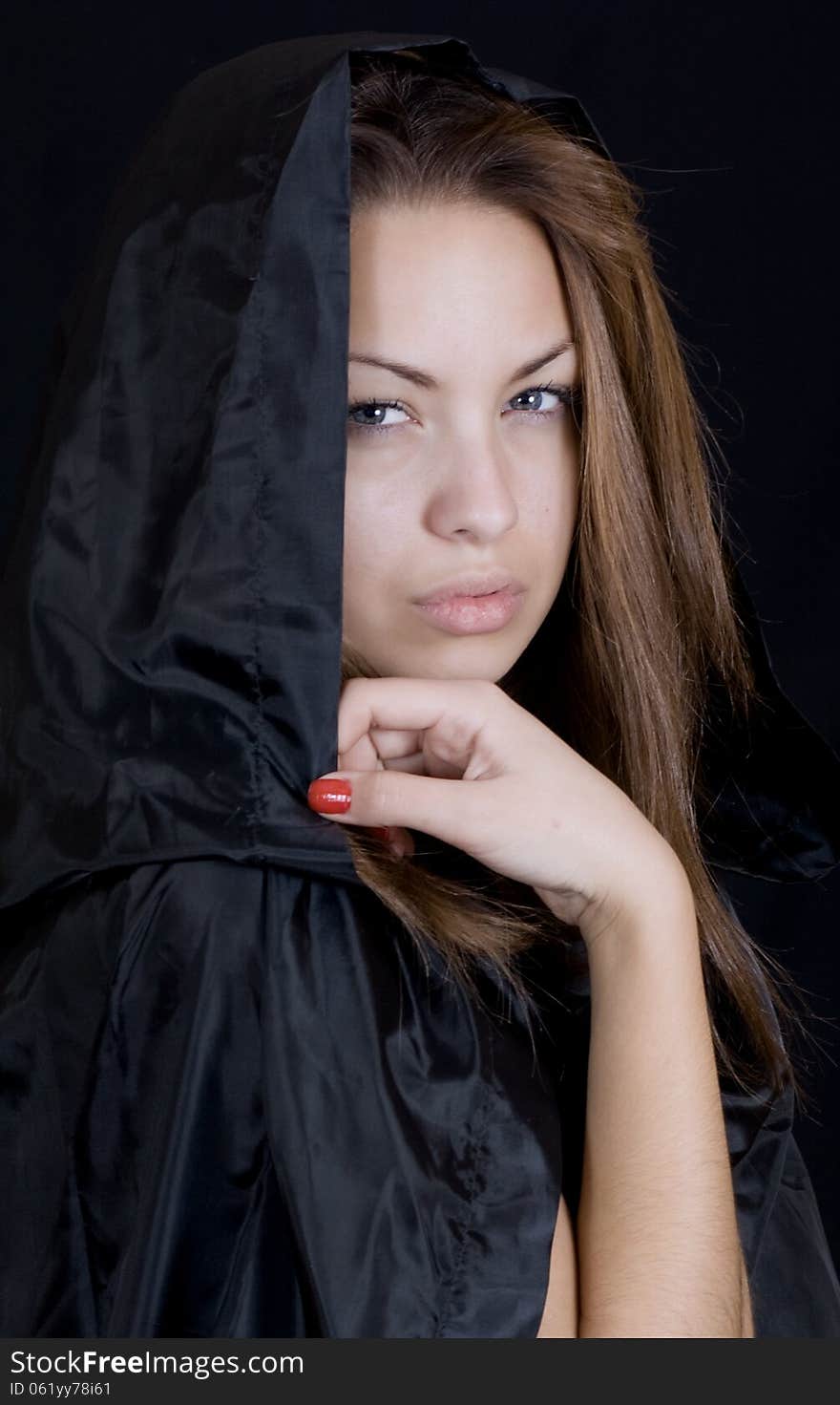 Dramatic portrait of a young lady in a black cape, may-be a young witch