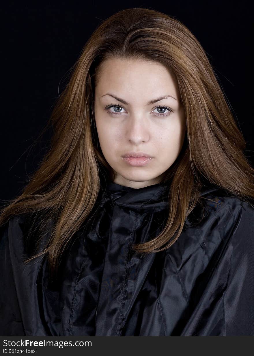 Dramatic portrait of a young lady in a black cape, may-be a young witch