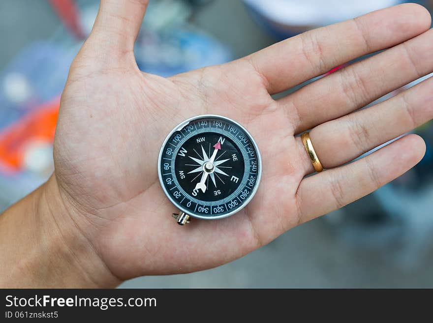 Metal compass on bare hand