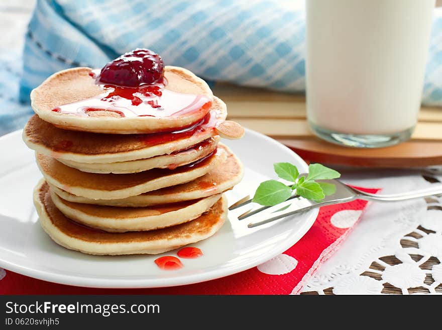 Pancakes on a white plate with strawberry jam. Pancakes on a white plate with strawberry jam