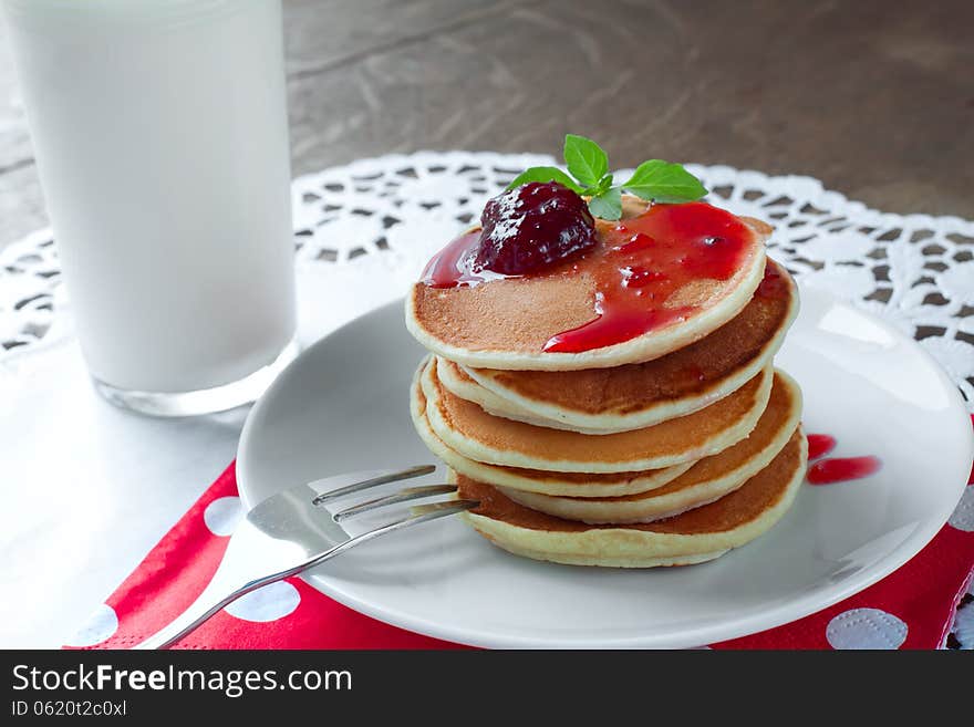 Pancakes on a white plate with strawberry jam. Pancakes on a white plate with strawberry jam