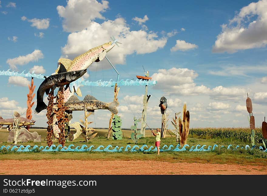 Metal sculptures of fish fisherman and boat in one of the rural region of North Dakota ,composition is unique by size. Metal sculptures of fish fisherman and boat in one of the rural region of North Dakota ,composition is unique by size.