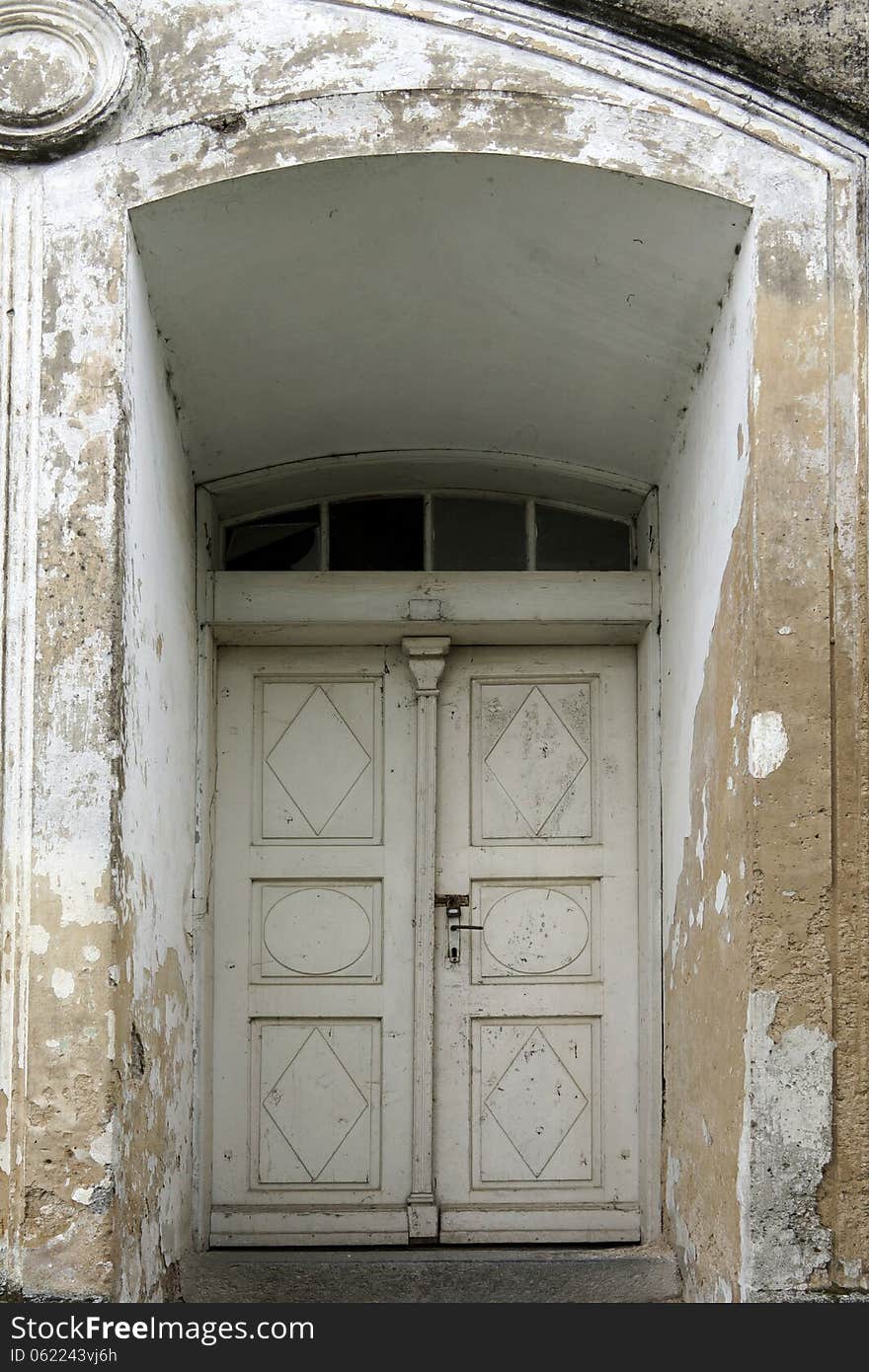 Old white double doors with an arch