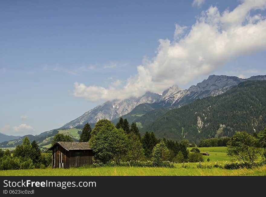 An old wooden barn on the background of  the alps mountains