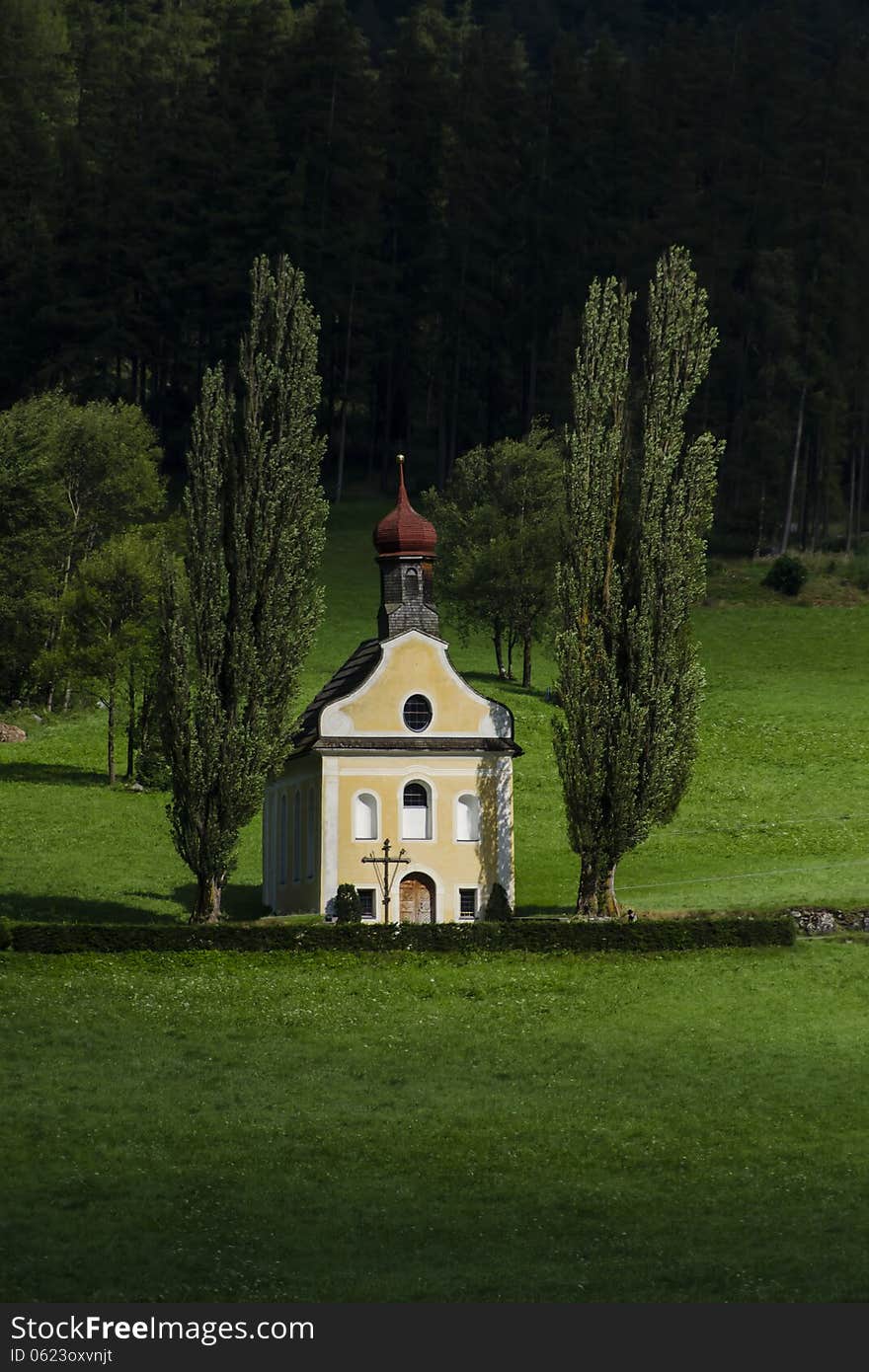 Small church surrounded with green grass and trees Austria