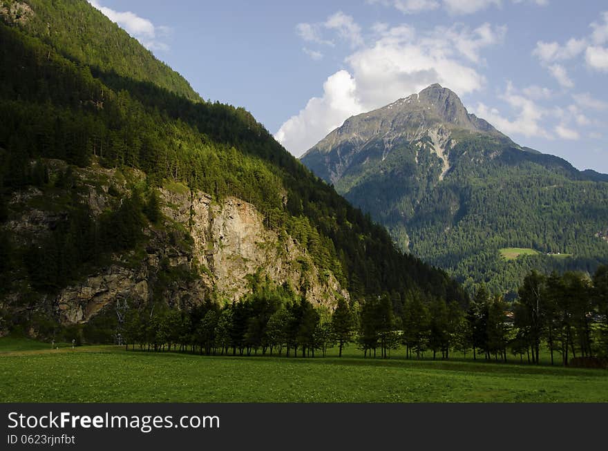 Alps Mountains Peak With Green Field