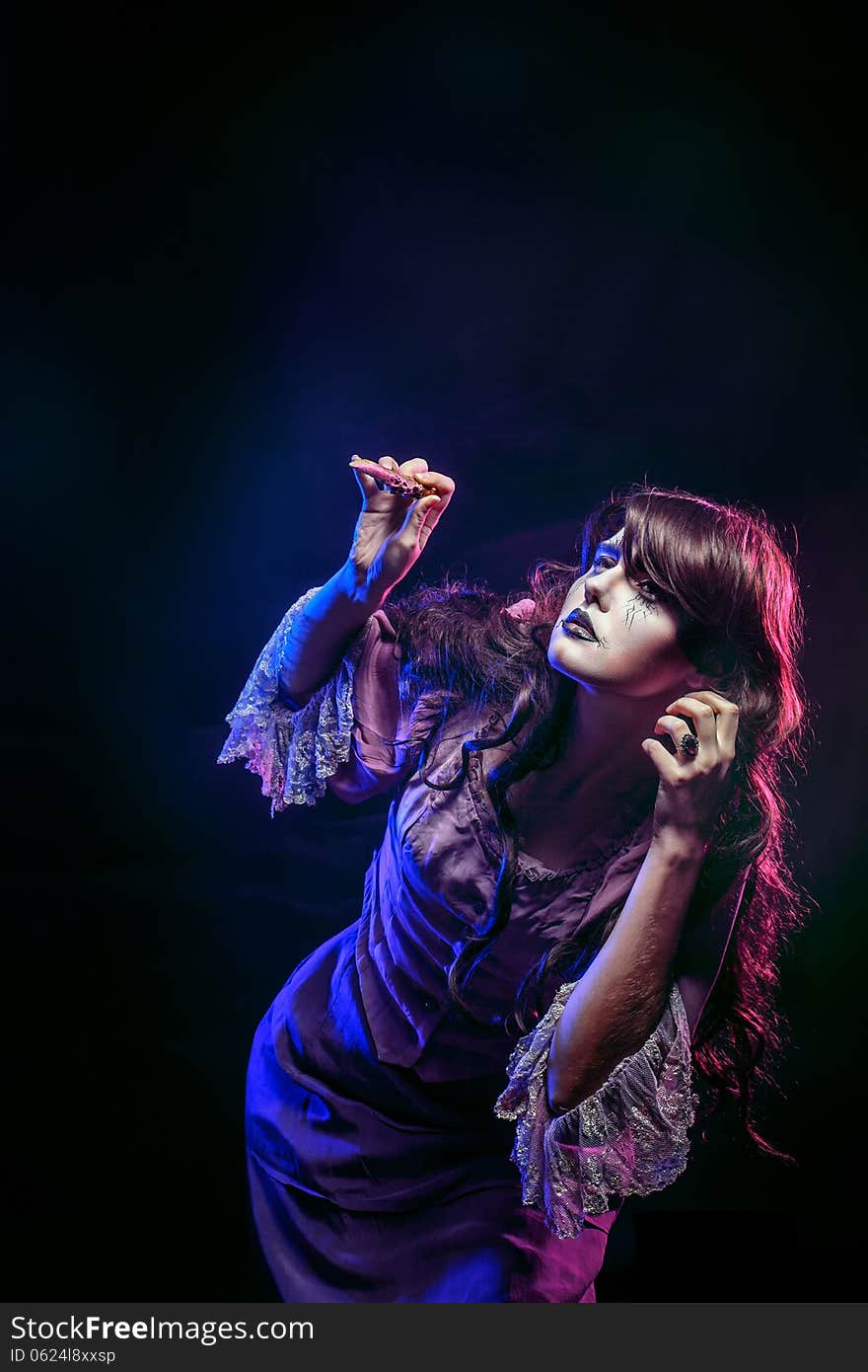 Girl in the image of a witch with a magic wand shot in studio. Girl in the image of a witch with a magic wand shot in studio