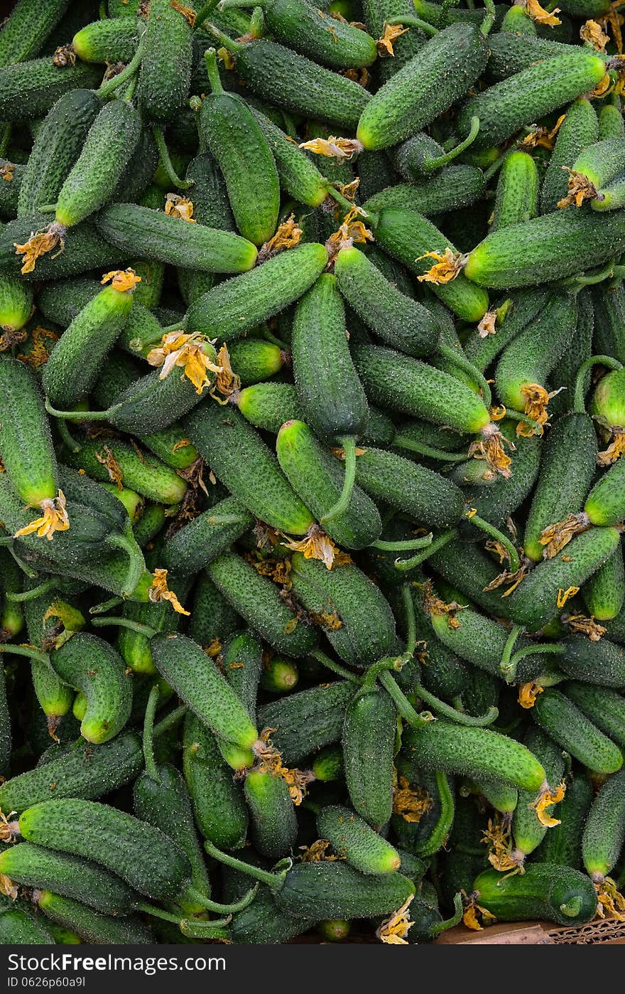 Full frame of gherkins background - heap of gherkins in cardboard box, ready for sale