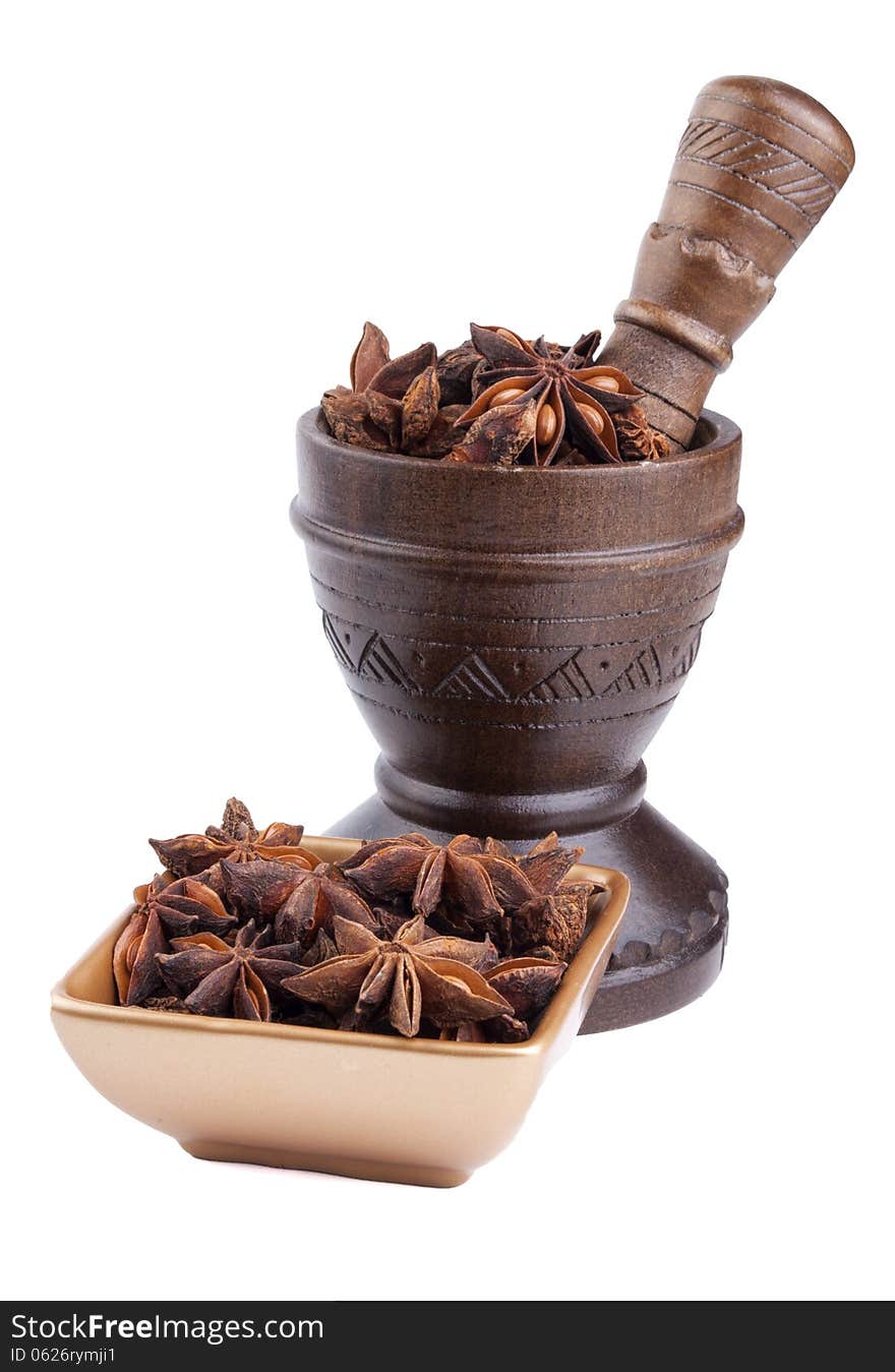 Anise stars in golden bowl and wooden mortar