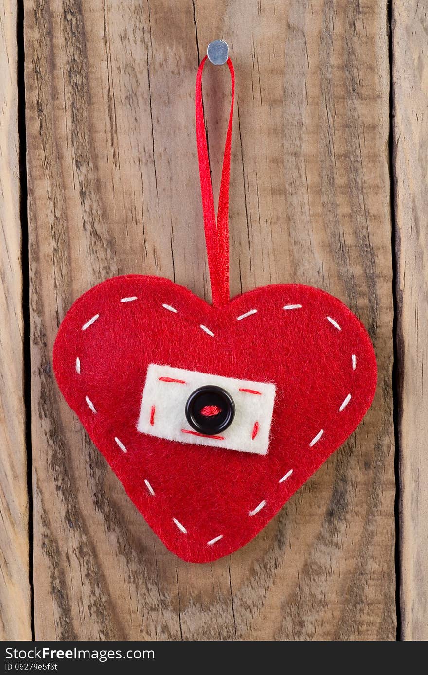 Heart decoration hanging against wooden background