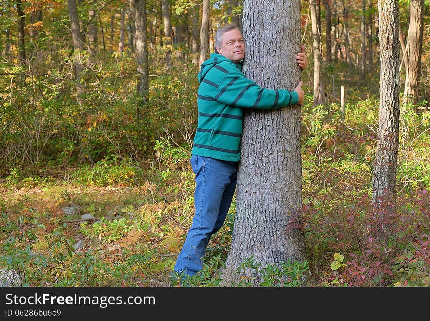 Man shown hugging tree expressing love for nature and environment. Man shown hugging tree expressing love for nature and environment.