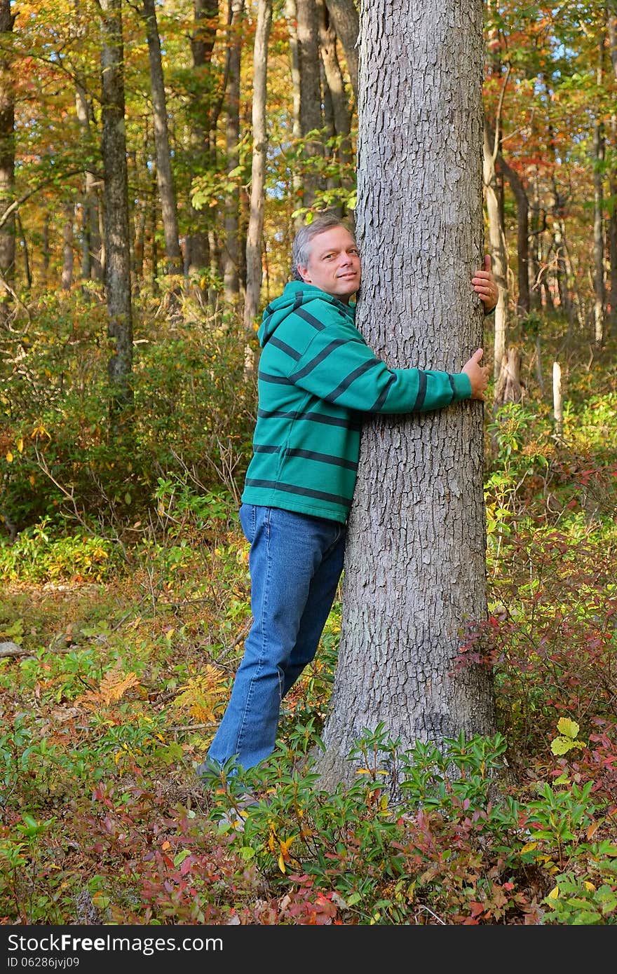 Man shown hugging tree expressing love for nature and environment. Man shown hugging tree expressing love for nature and environment.