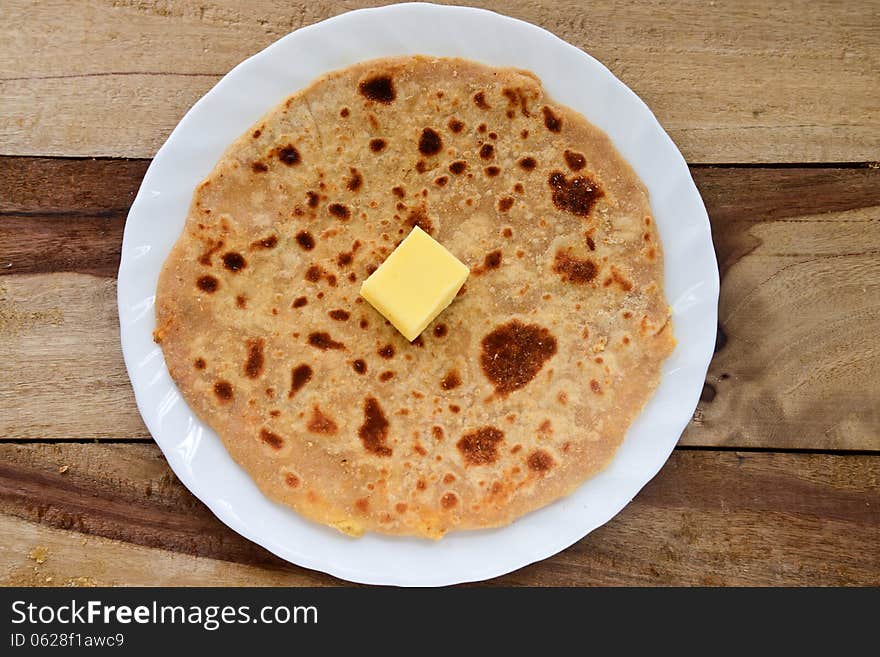 Stack of Indian Parantha (stuffed Indian bread) a plate with butter. Stack of Indian Parantha (stuffed Indian bread) a plate with butter