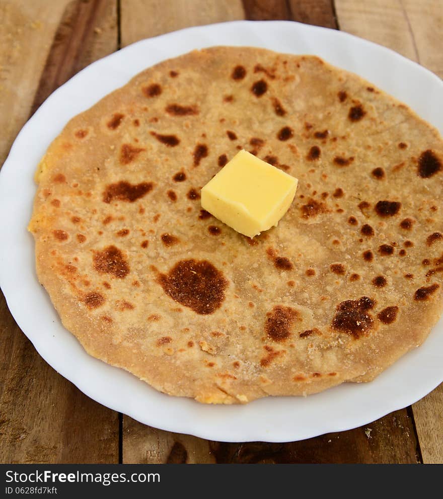 Stack of Indian Parantha (stuffed Indian bread) a plate with butter. Stack of Indian Parantha (stuffed Indian bread) a plate with butter