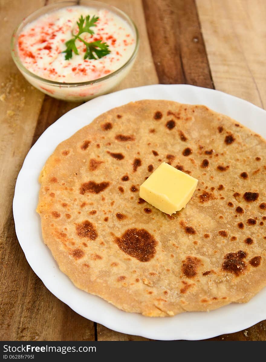 Stack of Indian Parantha (stuffed Indian bread) a plate with butter. Stack of Indian Parantha (stuffed Indian bread) a plate with butter