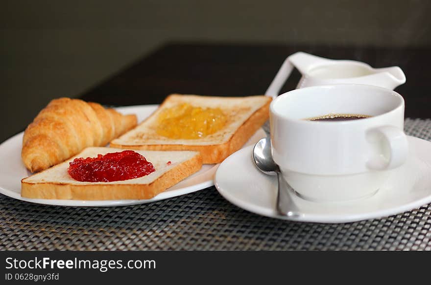 Breakfast meal with croissant bread jam and coffee