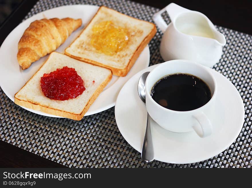 Breakfast meal with croissant bread jam and coffee