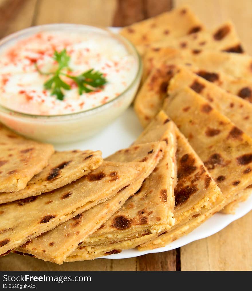 Stack of Indian Parantha (stuffed Indian bread) a plate with Curd. Stack of Indian Parantha (stuffed Indian bread) a plate with Curd