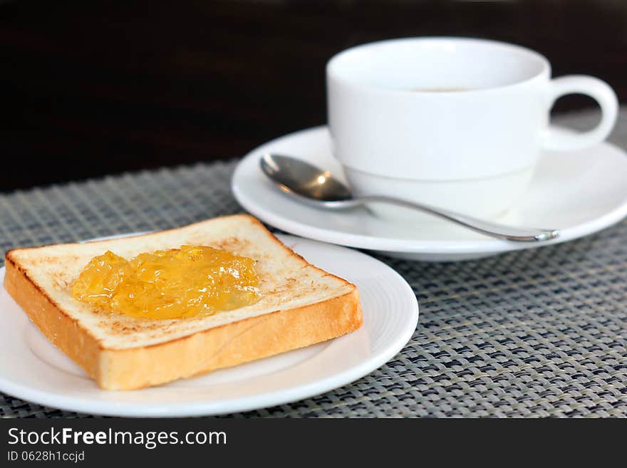 Pineapple jam on bread and coffee cup