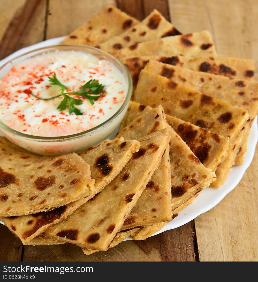 Stack of Indian Parantha (stuffed Indian bread) a plate with Curd. Stack of Indian Parantha (stuffed Indian bread) a plate with Curd