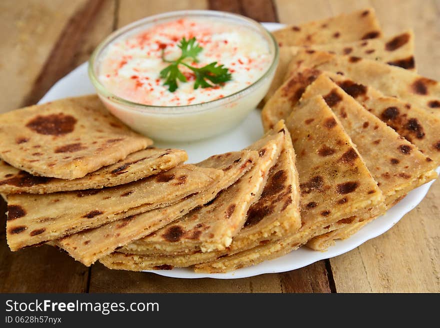 Stack of Indian Parantha (stuffed Indian bread) a plate with Curd. Stack of Indian Parantha (stuffed Indian bread) a plate with Curd