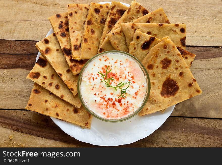 Stack of Indian Parantha (stuffed Indian bread) a plate with Curd. Stack of Indian Parantha (stuffed Indian bread) a plate with Curd