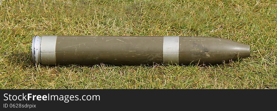 A Display Military Artillery Shell Laying on the Grass. A Display Military Artillery Shell Laying on the Grass.