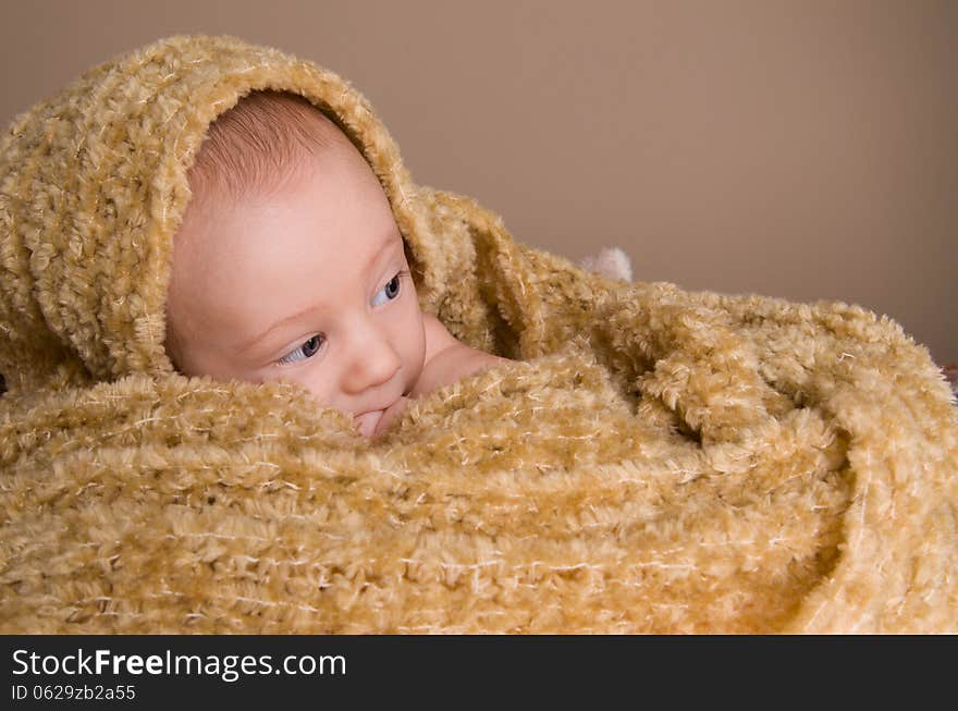 Newborn baby wrapped in  light brown soft fluffy cloth