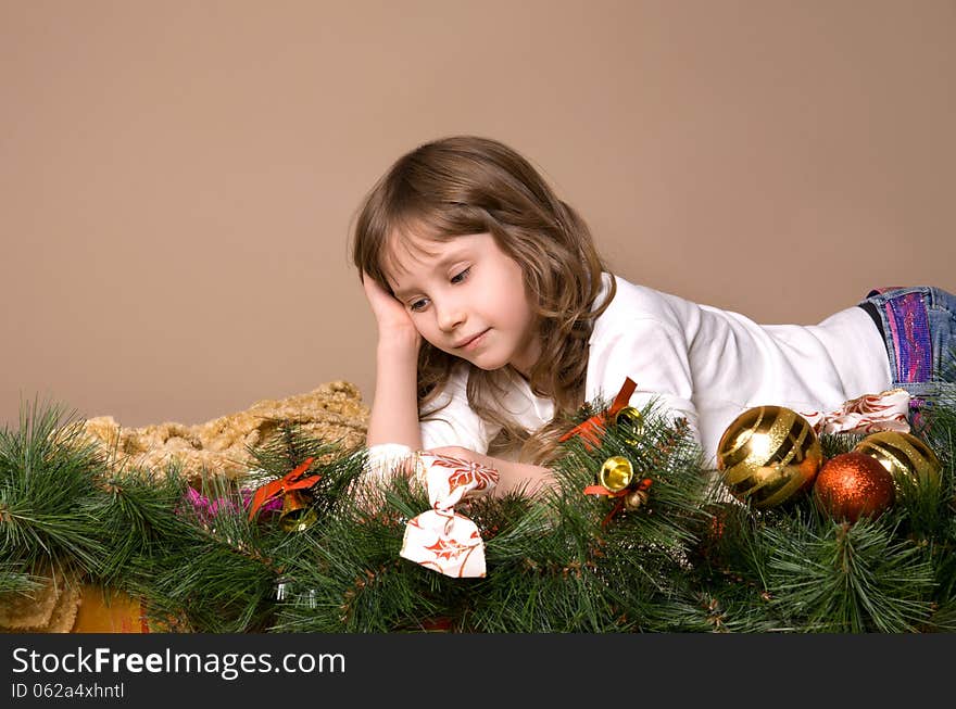 Child is lying and dreaming near tree decorations on eve of Christmas. Child is lying and dreaming near tree decorations on eve of Christmas