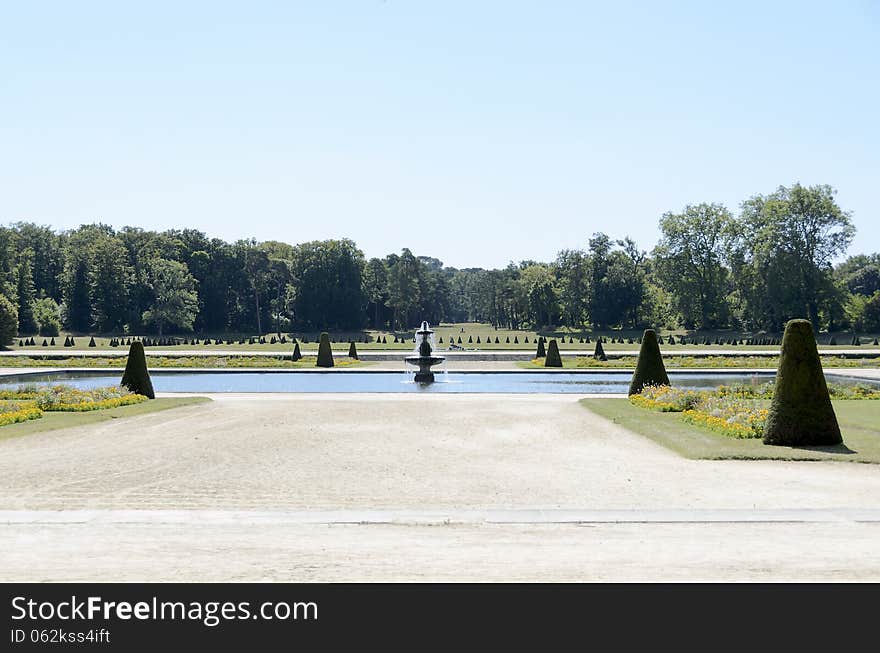 Outdoor garden with a fountain at the castle of fontainebleau.