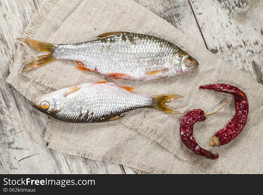 Two roaches fish on a linen napkin, near the old cutlery. From the series Still Life with fresh fish. Two roaches fish on a linen napkin, near the old cutlery. From the series Still Life with fresh fish