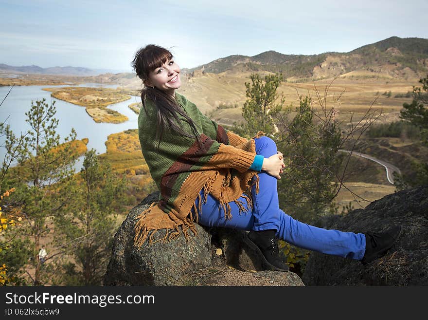 Beautiful woman posing on a rock in the mountains with lake. Beautiful woman posing on a rock in the mountains with lake