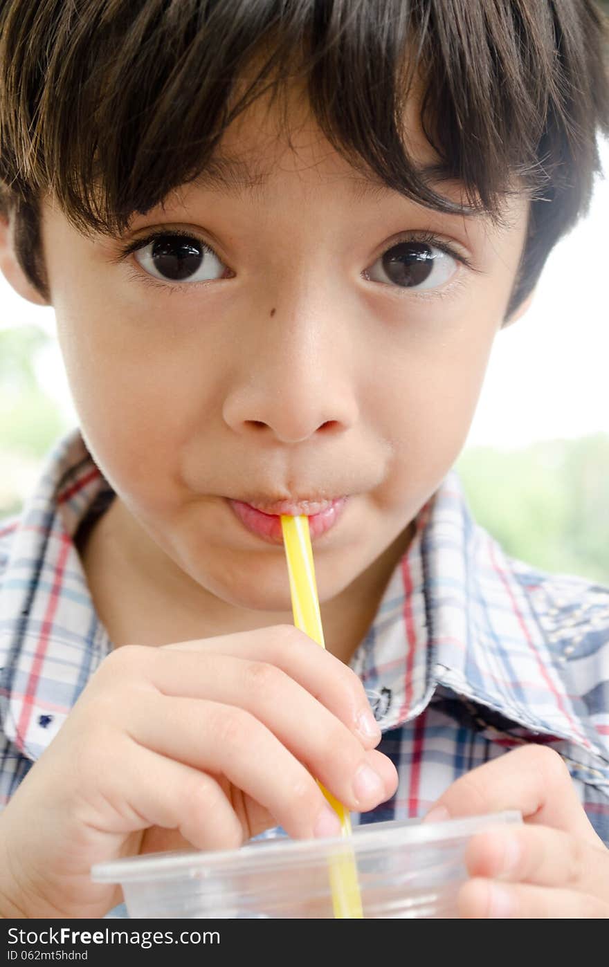 Little asian boy smiling drinkin water