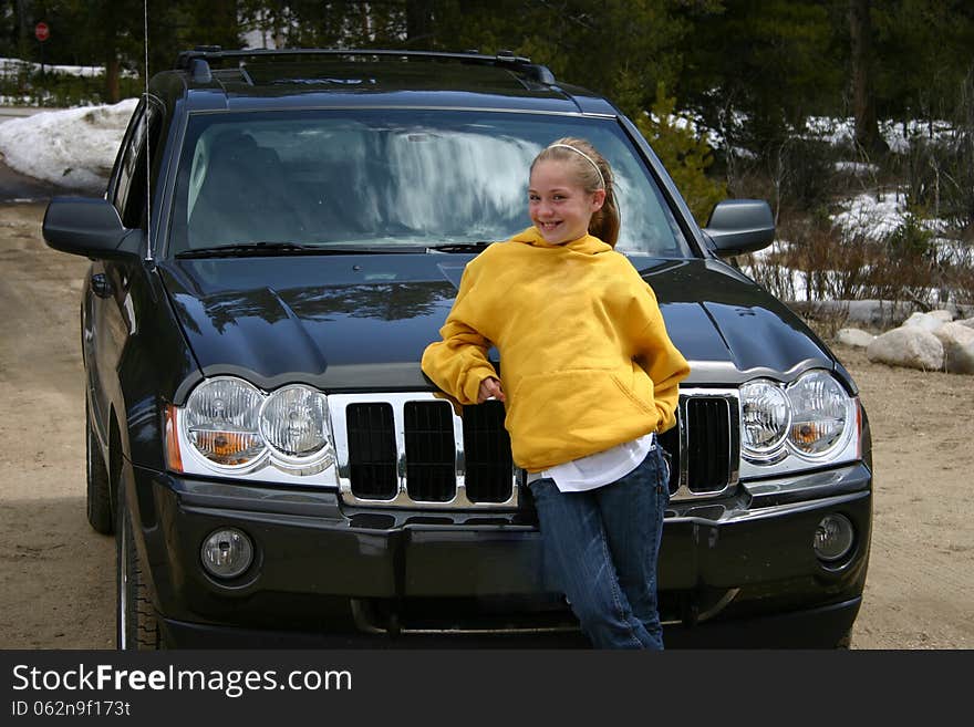 Teen Girl Standing In Front Of An SUV