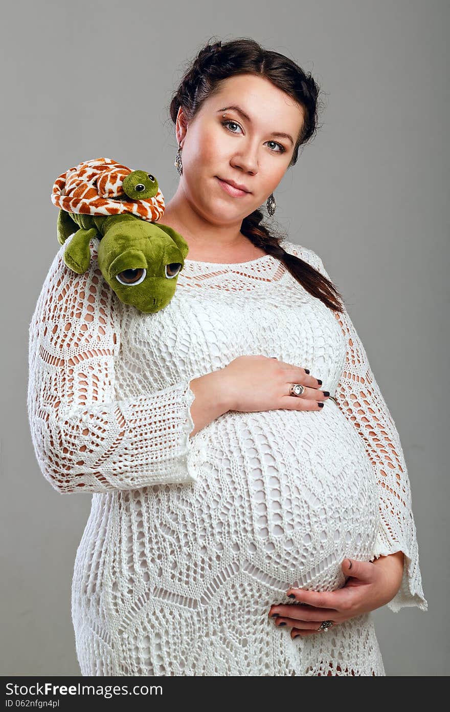 Attractive pregnant girl in a beautiful dress, shot in the studio. Attractive pregnant girl in a beautiful dress, shot in the studio