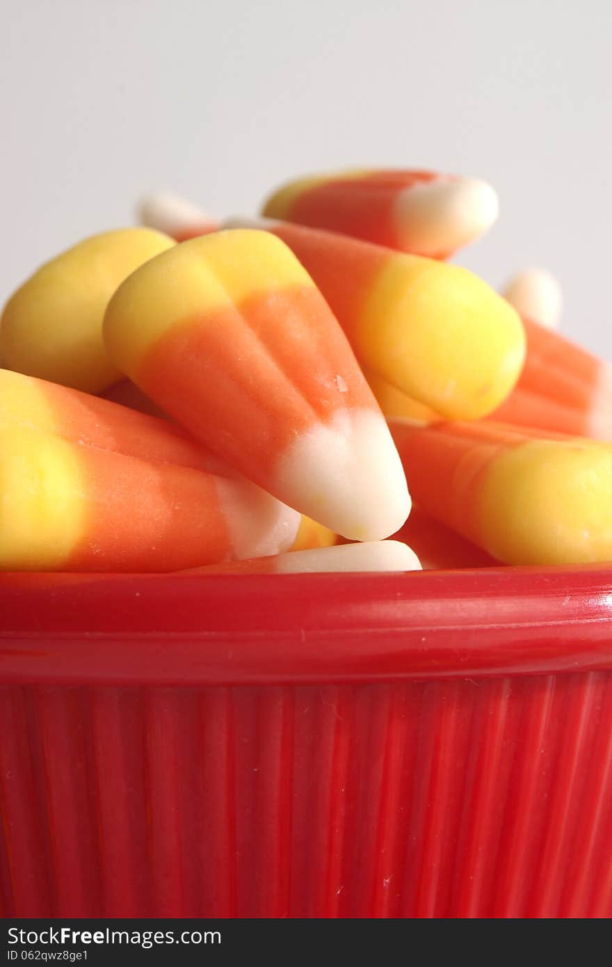 Lots of candy corn in a red bowl