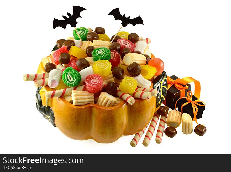 Pumpkin dish full of sweets and gifts isolated. Pumpkin dish full of sweets and gifts isolated