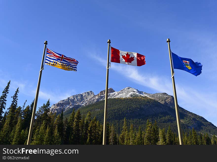 Canadian national flag, British Columbia provincial flag and Alberta provincial flag at the provincial border, Canada;. Canadian national flag, British Columbia provincial flag and Alberta provincial flag at the provincial border, Canada;