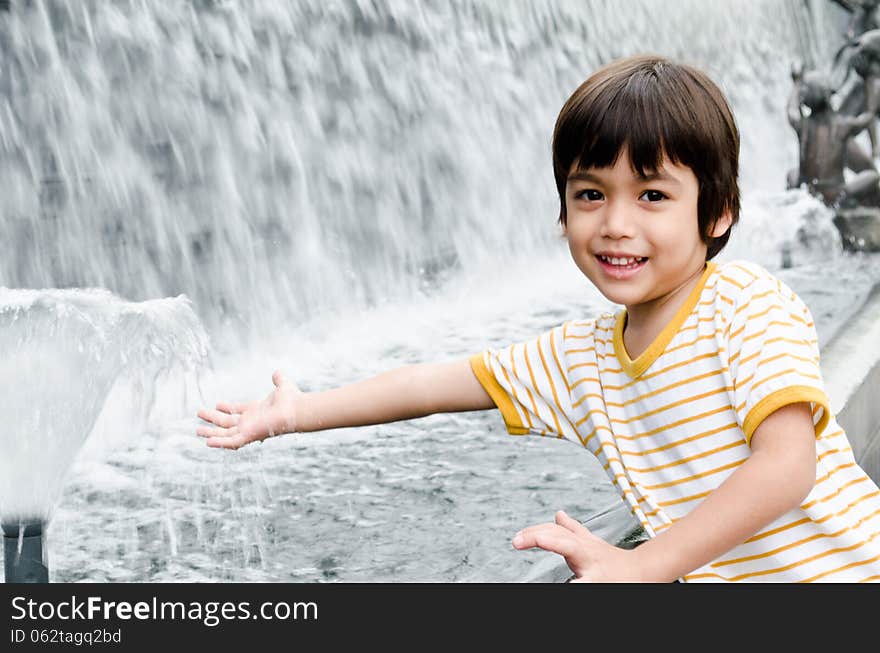 Little boy playing water fountain daylight fresh