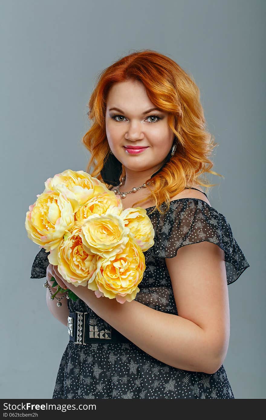 Attractive red-haired girl holding a bouquet of yellow flowers. Attractive red-haired girl holding a bouquet of yellow flowers